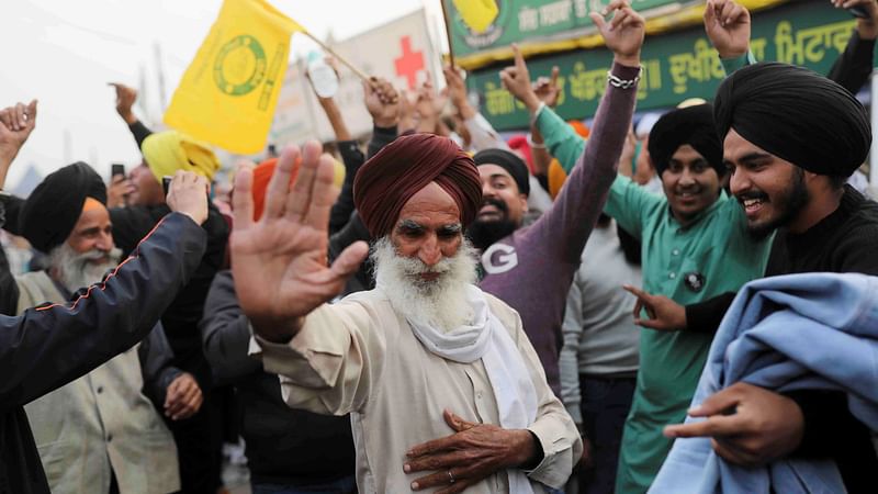 Farmers celebrate after Prime Minister Narendra Modi announced that he will repeal the controversial farm laws, at the Singhu border farmers protest site near the Delhi-Haryana border, India, on 19 November 2021