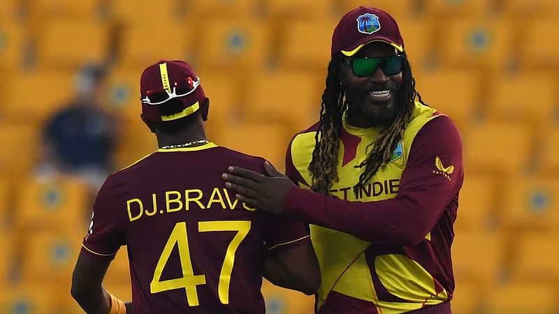 West Indies' Chris Gayle (R) greets his teammate Dwayne Bravo at the end of the ICC men’s Twenty20 World Cup cricket match between Australia and West Indies at the Sheikh Zayed Cricket Stadium in Abu Dhabi on 6 November 2021.