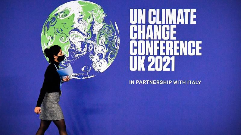 A participant walks past a COP26 UN Climate Change Conference' poster on the first day of the COP26 UN Climate Change Conference at the Scottish Event Campus (SEC) in Glasgow, Scotland, on 31 October, 2021