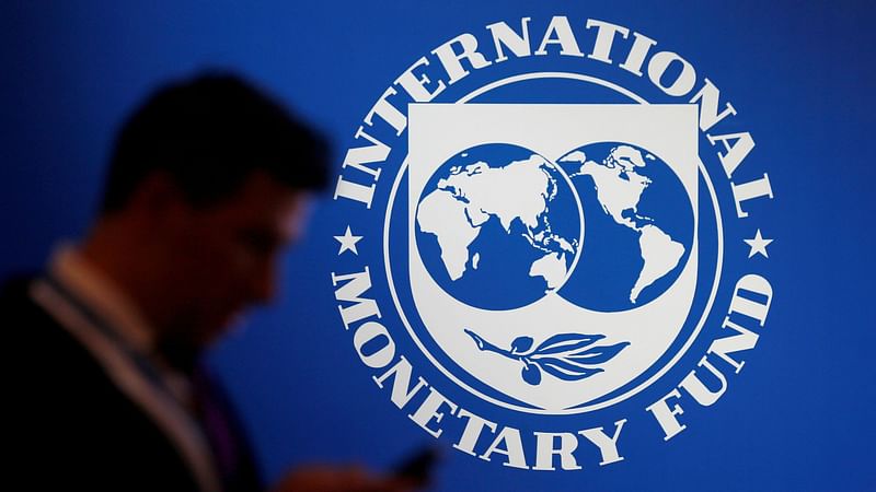 A participant stands near a logo of IMF at the International Monetary Fund - World Bank Annual Meeting 2018 in Nusa Dua, Bali, Indonesia, 12 October 2018.