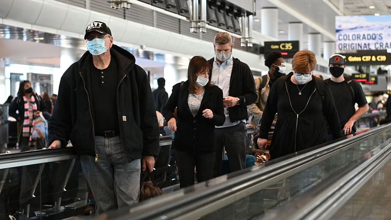 Travelers wear protective face masks at Denver International Airport on 30 November, 2021 in Denver, Colorado as concern grows worldwide over the Omicron coronavirus variant