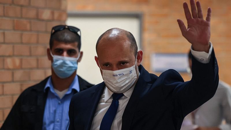 Israeli prime minister Naftali Bennett gestures in greeting as he walks into the Knesset, Israel's Parliament, in Jerusalem on 7 June 2021