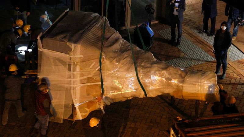 Workers remove a part of "Pillar of Shame" by Danish sculptor Jens Galschiot which to pay tribute to the victims of the Tiananmen Square crackdown in Beijing on 4 June 1989, at the University of Hong Kong (HKU) in Hong Kong, China, on 23 December 2021