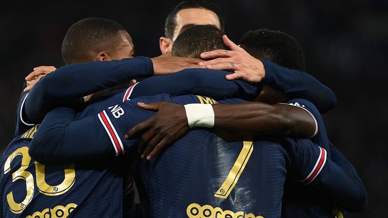 Paris Saint-Germain's French forward Kylian Mbappe (L) celebrates with teammates after scoring a goal during the French L1 football match between Paris Saint-Germain (PSG) and AS Monaco at the Parc des Princes stadium in Paris, on 12 December, 2021