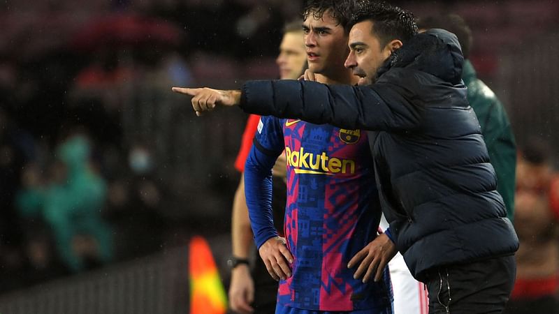 Barcelona's Spanish coach Xavi gives instructions to Barcelona's Spanish midfielder Gavi during the UEFA Champions League Group E football match between FC Barcelona and SL Benfica, at the Camp Nou stadium in Barcelona on 23 November, 2021