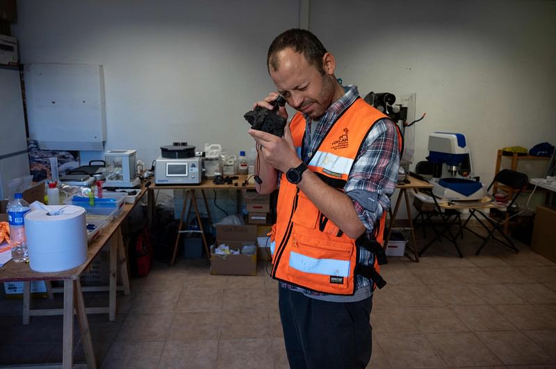 Australian geoscientist Matt Pankhurst examines a sample of lava at the stones laboratory near Los Llanos de Aridane on the Canary island of La Palma on December 11, 2021