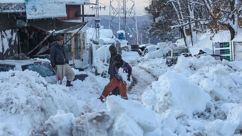 People work to clear a road after a heavy snowfall in Murree, around 70 kilometres (45 miles) northeast of the capital, Islamabad after an incident earlier where at least 21 people died in an enormous traffic jam caused by tens of thousands of visitors thronging to a Pakistani hill town to see unusually heavy snowfall.