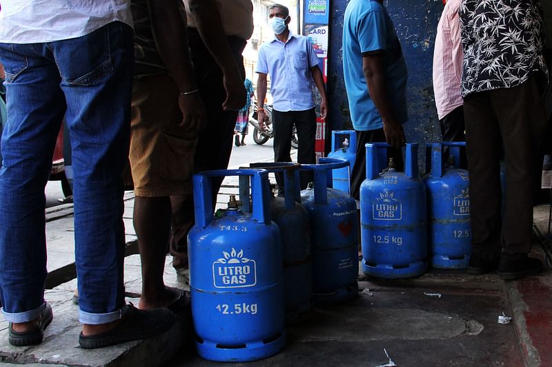 People queue to buy Liquefied Petroleum Gas (LPG) cylinders in Colombo on 19 January 2022, as shortages of essentials gripped the island following a severe shortage of foreign exchange to finance imports