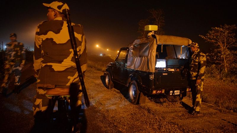 In this picture taken on 30 December 2021, Indian Border Security Force (BSF) soldiers patrol along an unfenced area at the India Bangladesh border outpost in Phansidewa village, about 35km from Siliguri