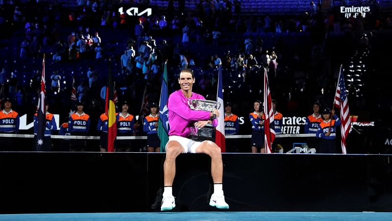 Spain's Rafael Nadal smile as he holds the Norman Brookes Challenge Cup trophy following his victory against Russia's Daniil Medvedev in their men's singles final match on day fourteen of the Australian Open tennis tournament in Melbourne on 30 January, 2022