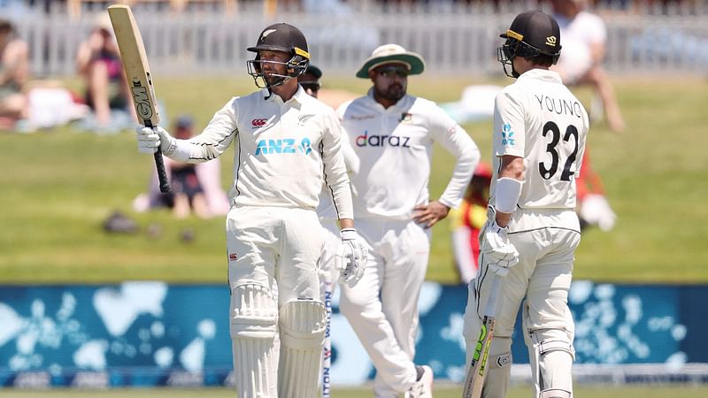 New Zealand’s batsman Devon Conway (L) celebrates reaching his half century (50 runs) on day one of the first cricket Test match between New Zealand and Bangladesh at the Bay Oval in Mount Maunganui on 1 January, 2022