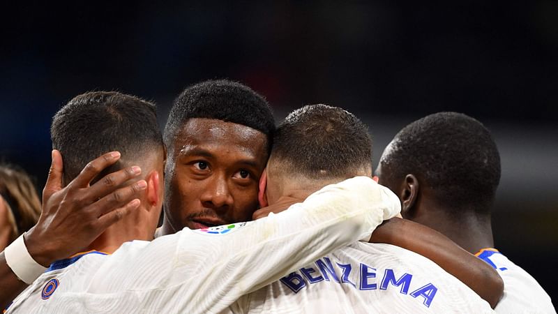 Real Madrid's French forward Karim Benzema (2R) celebrates with Real Madrid's Austrian defender David Alaba (2L) and teammates after scoring the opening goal during the Spanish league football match between Real Madrid CF and Valencia CF at the Santiago Bernabeu stadium in Madrid on 8 January, 2022