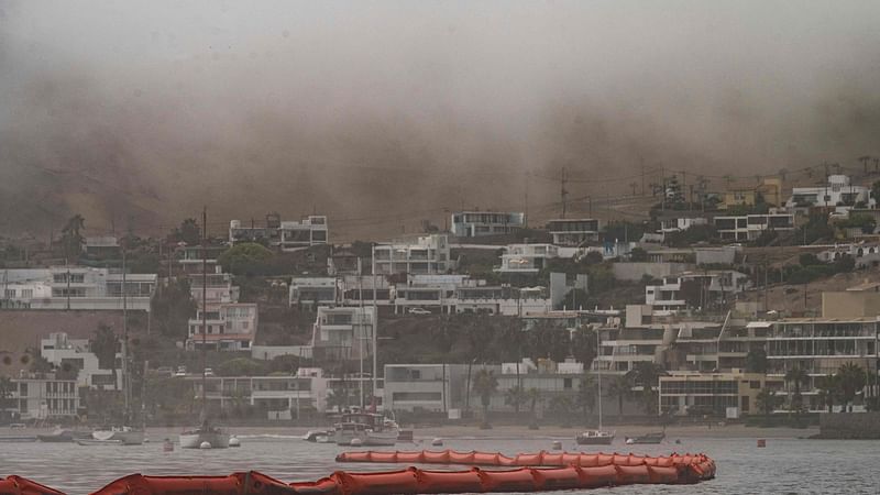 Floating barriers to protect the beaches from drifting oil are seen at the resort town of Ancon, Peru, on 21 January, 2022