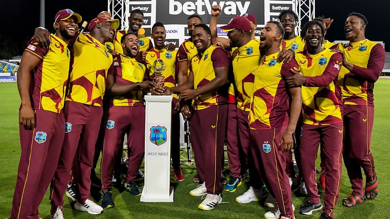 West Indies's players pose with the winning trophy at the end of the 5th and final T20I between West Indies and England at Kensington Oval, Bridgetown, Barbados, on 30 January, 2022