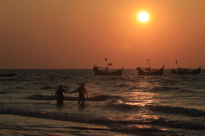 A couple enjoys the last sunset of 2021 at St. Martin Island. The picture was taken from 31 December.