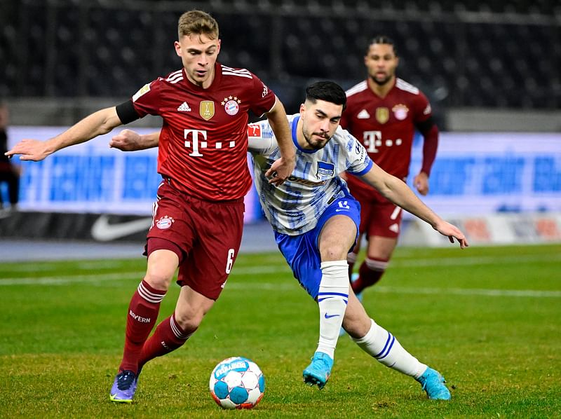 Bayern Munich's German midfielder Joshua Kimmich (L) and Hertha Berlin's German midfielder Suat Serdar (C) vie for the ball during the German first division Bundesliga football match between Hertha Berlin and Bayern Munich in Berlin on 23 January, 2022