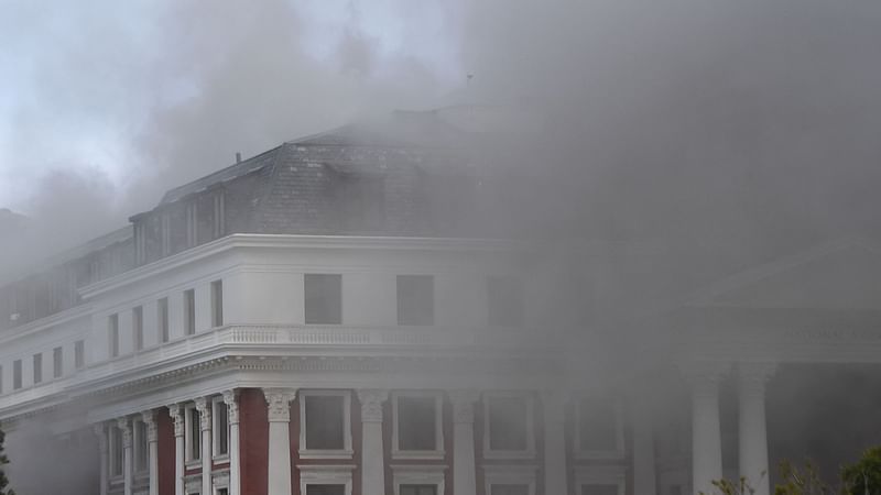 Smoke billows from the roof of a building at the South African Parliament precinct in Cape Town on 2 January, 2022