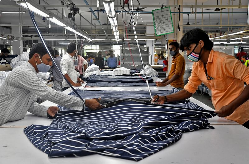 Garment workers cut fabric to make shirts at a textile factory of Texport Industries in Hindupur town in the southern state of Andhra Pradesh, India, on 9 February 2022