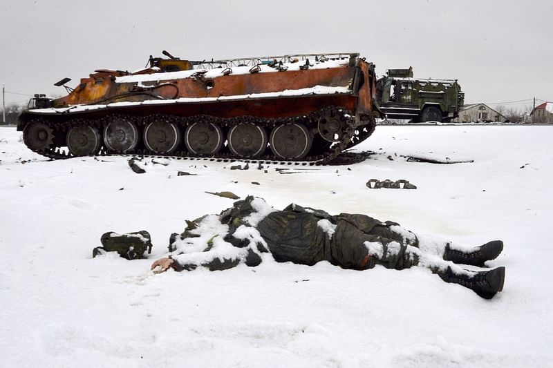 The body of a Russian serviceman lies near destroyed Russian military vehicles on the roadside on the outskirts of Kharkiv on 26 February 2022, following the Russian invasion of Ukraine