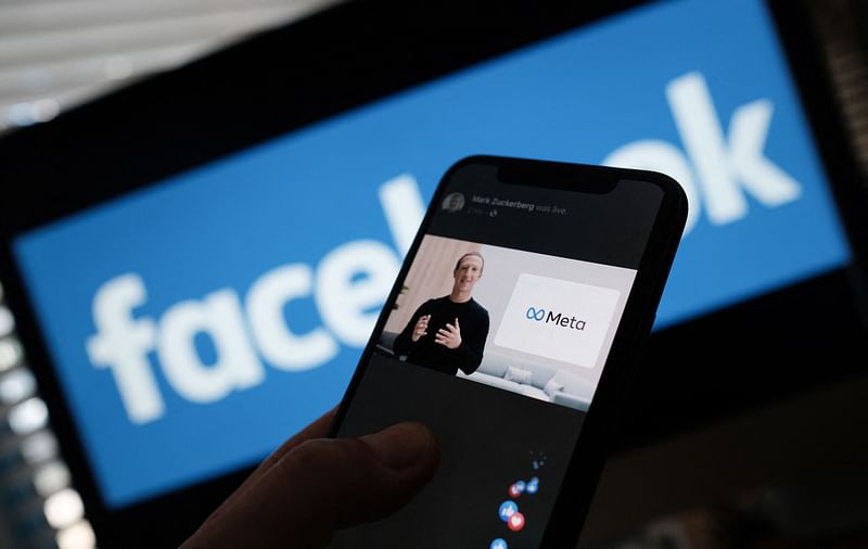 This file photo taken on 28 October 2021 shows an illustration photo taken in Los Angeles of a person watches on a smartphone Facebook CEO Mark Zuckerberg unveiling the META logo