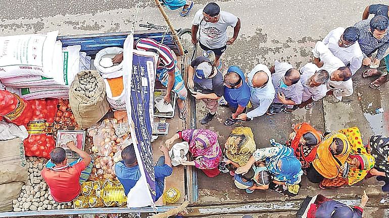 Consumers' que before a TCB truck in Dhaka as food prices continue to rise