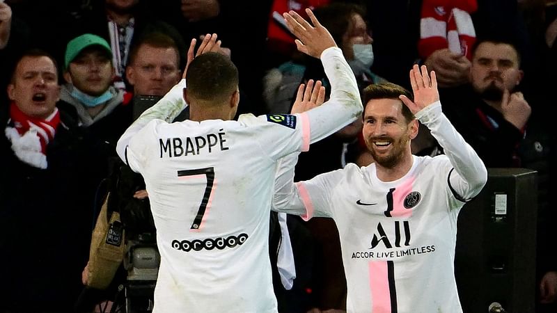 Paris Saint-Germain's Argentinian forward Lionel Messi (R) is congratulated by Paris Saint-Germain's French forward Kylian Mbappe (L) after scoring a goal during the French L1 football match between Lille and Paris Saint-Germain at the Pierre-Mauroy stadium in Villeneuve-d'Ascq, near Lille, on 6 February, 2022.