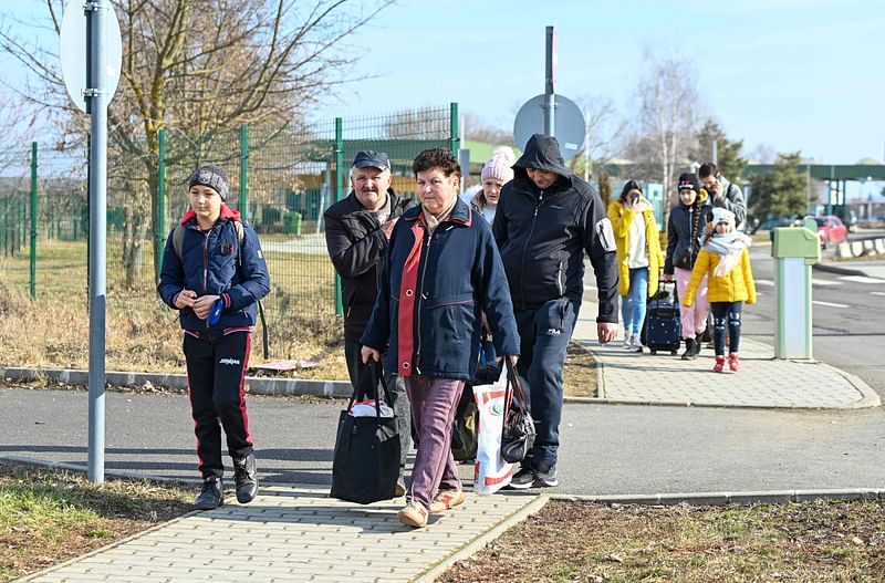 Ukrainian citizens fleeing the conflict in their country are seen after crossing the Hungarian-Ukrainian border near Beregsurany, Hungary, some 300 km from the Hungarian capital on 25 February 2022, one day after Russia launched a military attack on neighbouring Ukraine.