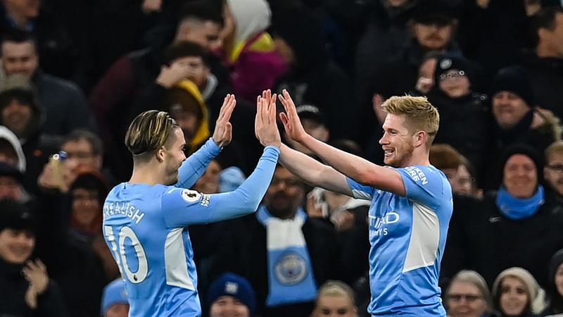 Manchester City's Belgian midfielder Kevin De Bruyne (R) celebrates with English midfielder Jack Grealish (L) after scoring a goal during the English Premier League football match against Brentford at the Etihad Stadium in Manchester, north west England, on 9 February, 2022