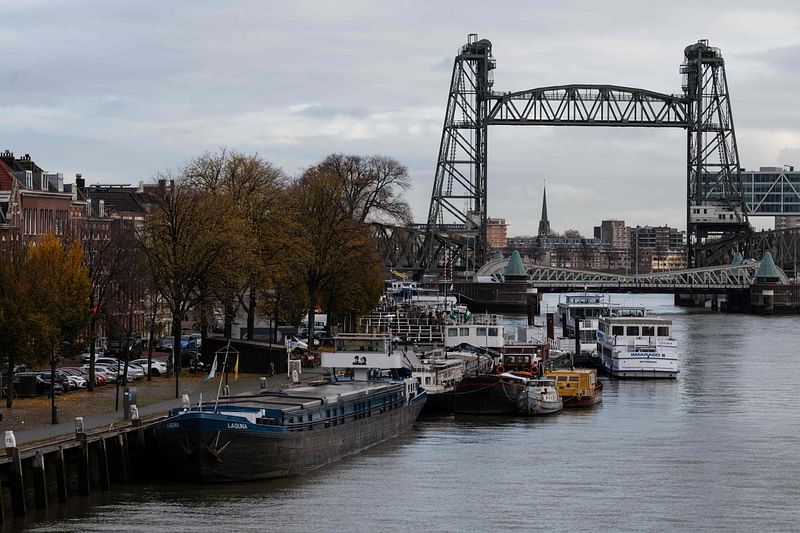 This file photo taken on 23 November 2021 shows barges docked on the Koningshaven waterway as they Koningshavenbrug "De Hef" lift bridge (R, rear) and the Koninginnebrug drawbridge (R, front) are seen in the background in Rotterdam, western Netherlands