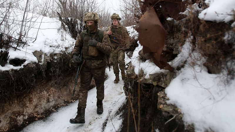 Ukrainian servicemen walk along a snow covered trench on the frontline with the Russia-backed separatists near Avdiivka, Donetsk region, on 2 February, 2022