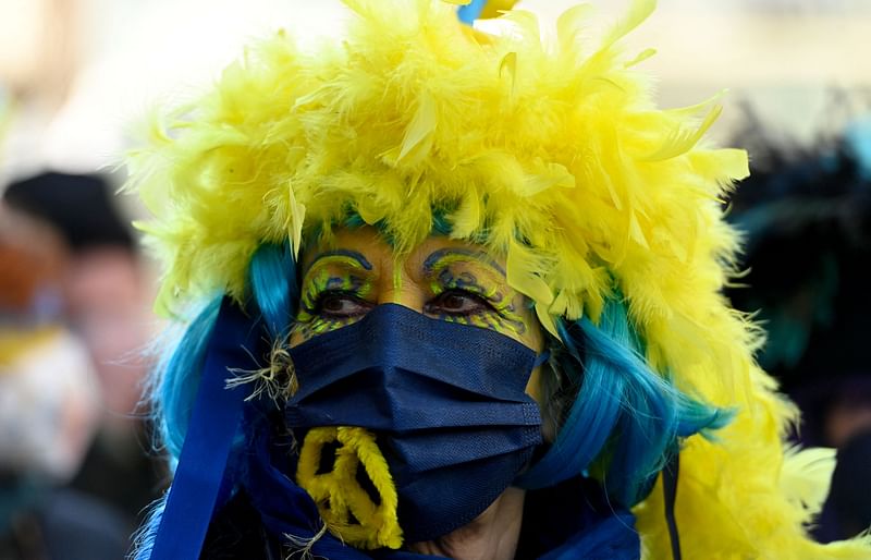 A reveller is made up in the colors Ukraine during a peace march titled "Freedom for Ukraine" replacing the traditional Rose Monday carnival street parade in Cologne, western Germany, on 28 February 2022.