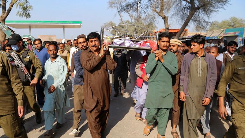 People carry the body of a man, who according to the police, was lynched by a mob for allegedly burning pages of Muslim holy book, "The Koran" in Tulamba Village, in Mian Channu, Pakistan, 13 February 2022.