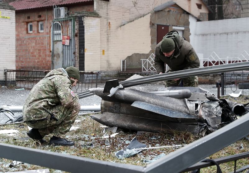 Police officers inspect the remains of a missile that fell in the street, after Russian President Vladimir Putin authorized a military operation in eastern Ukraine, in Kyiv, Ukraine on 24 February 2022