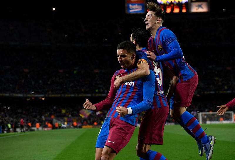 Barcelona's Spanish forward Ferran Torres (L) celebrates with teammates after scoring a goal during the Spanish league football match between FC Barcelona and CA Osasuna at the Camp Nou stadium in Barcelona on 13 March, 2022