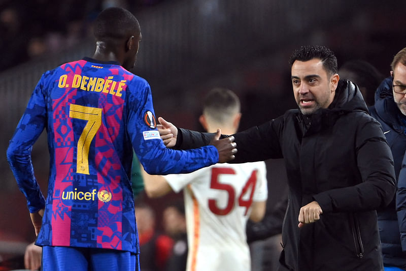 Barcelona's French forward Ousmane Dembele (L) listens to Barcelona's Spanish coach Xavi during the UEFA Europa League round of 16 first leg football match between FC Barcelona and Galatasaray at the Camp Nou stadium in Barcelona on 10 March, 2022