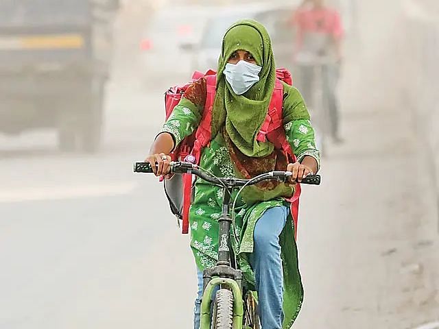 People struggle to deal with the dust and pollution. Picture taken on Wednesday in Shewrapara of Dhaka city.