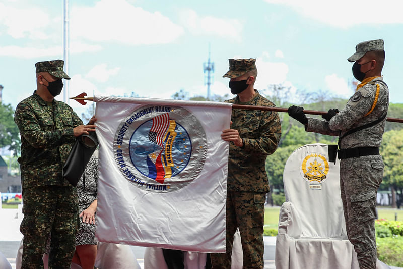 Philippine Balikatan Exercise Director Maj. Gen. Charlton Sean Gaerlan (L) and US Exercise Director Maj. Gen. Jay Bargeron (2nd R) unfurl the Balikatan flag during the opening ceremony for a 12-day joint military drill, at Camp Aguinaldo in Quezon City, east of Manila on 28 March 2022.