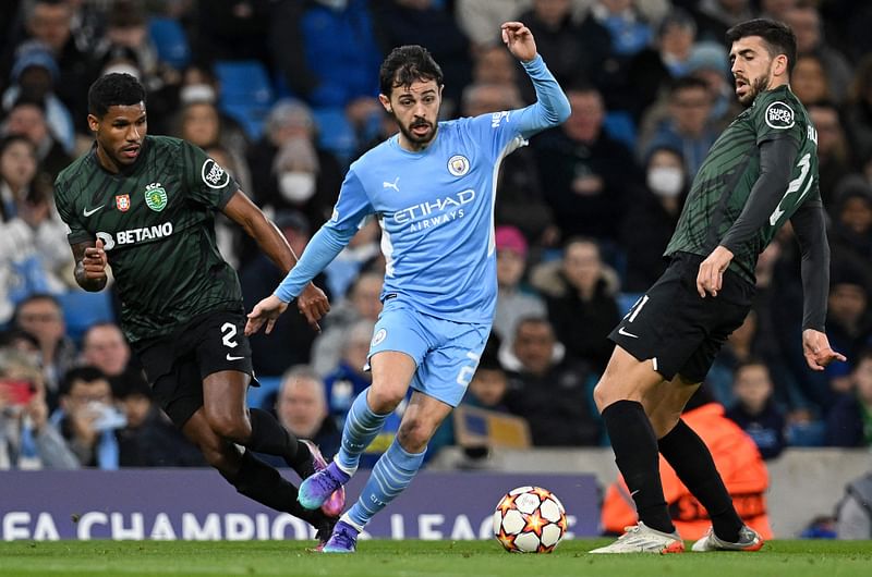 Sporting Lisbon's Brazilian defender Matheus Reis (L) and Portuguese striker Paulinho (R) vie with Manchester City's Portuguese midfielder Bernardo Silva during the UEFA Champions League round of 16 second leg football match at the Etihad Stadium in Manchester, north west England, on 9 March, 2022