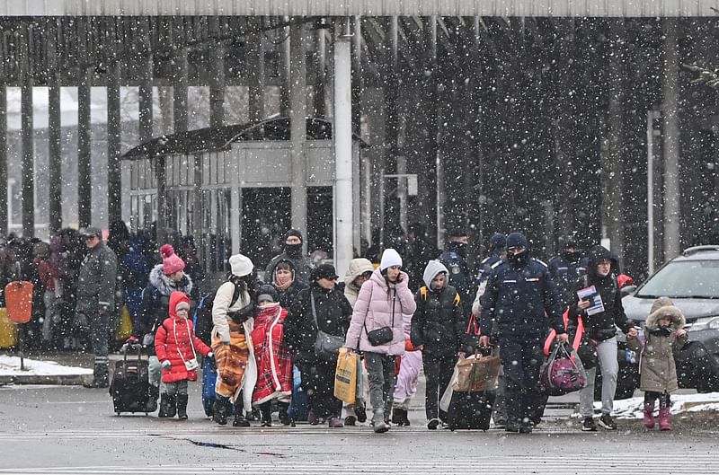 Refugees coming from Ukraine walk at the Ukrainian-Romanian border in Siret on 2 March 2022. Refugees from Ukraine flock into Romania to escape Russia's invasion -- and avoid massive jams at the Polish border.