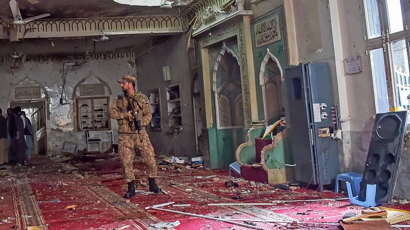 A soldier stands guard inside a mosque after a bomb blast in Peshawar on 4 March 2022.