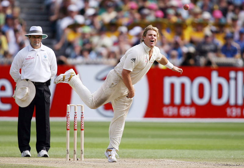 In this file photograph taken on 28 December 2006, Australian spinner Shane Warne (R) sends down a delivery as umpire Aleem Dar (L) looks on as Warne plays his last Test match on his home ground, the MCG, on the third day of the fourth cricket Test in Melbourne.