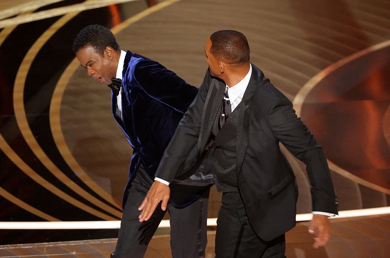 Will Smith (R) hits Chris Rock as Rock spoke on stage during the 94th Academy Awards in Hollywood, Los Angeles, California, US, 27 March, 2022