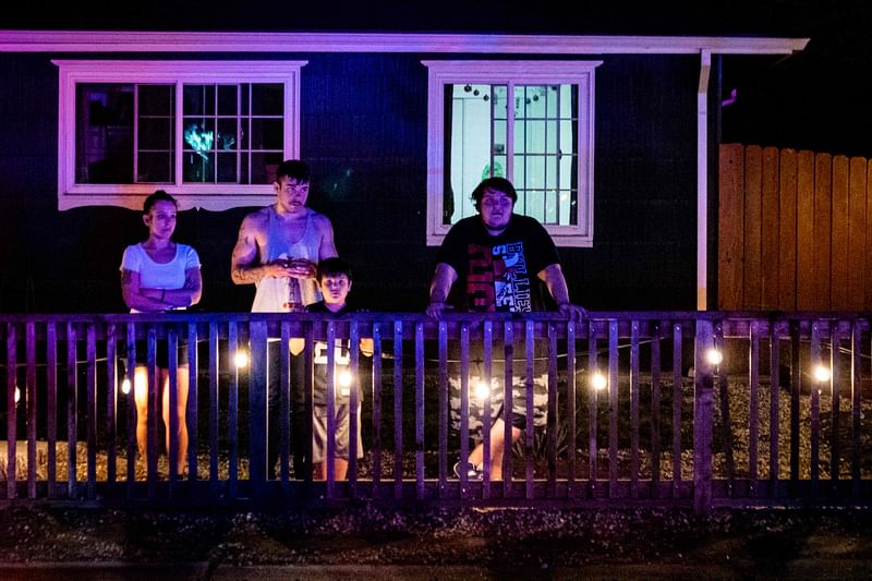 Local residents look toward the crime scene near a church where a man shot dead four people, including three of his children, before turning the gun on himself, 28 February 2022 in Sacramento, California.