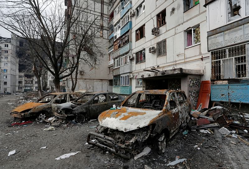 Destroyed cars are seen in front of an apartment building which was damaged during Ukraine-Russia conflict in the besieged southern port city of Mariupol, Ukraine on 27 March, 2022