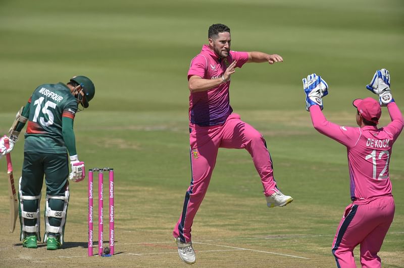 South Africa's Wayne Parnell (C) celebrates with teammate South Africa's wicketkeeper Quinton de Kock (R) after the dismissal of Bangladesh's Mushfiqur Rahim (L) during the second one-day international (ODI) cricket match between South Africa and Bangladesh at the Wanderers stadium in Johannesburg on 20 March, 2022