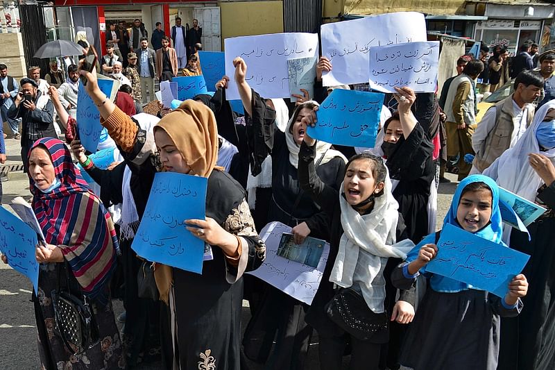 Afghan women and girls take part in a protest in front of the Ministry of Education in Kabul on 26 March 2022, demanding that high schools be reopened for girls.