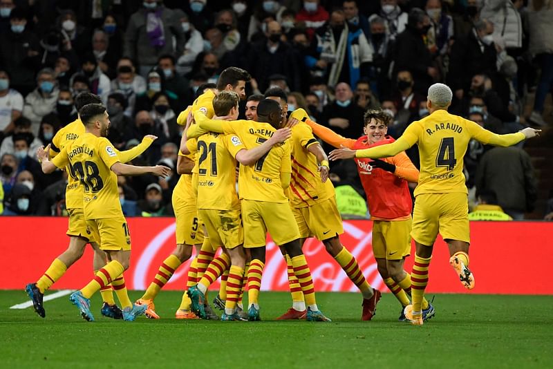 Barcelona's players celebrate after scoring a goal during the Spanish League football match between Real Madrid CF and FC Barcelona at the Santiago Bernabeu stadium in Madrid on 20 March, 2022