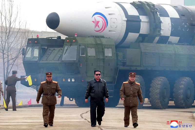 This file picture taken on 24 March, 2022 and released from North Korea's official Korean Central News Agency (KCNA) on 25 March, 2022 shows North Korean leader Kim Jong Un (C) walking near what state media report says was a new type inter-continental ballistic missile