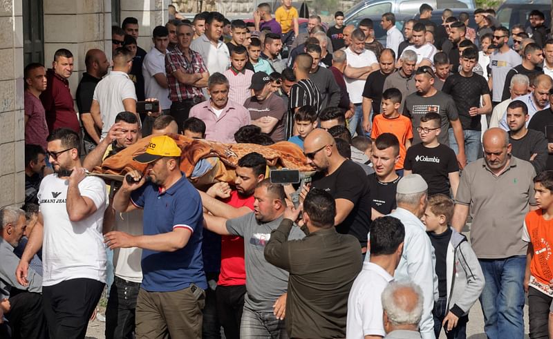 Palestinians carry the body of Ghada Sabatin, who died from her wounds after being shot by Israeli soldiers, during her funeral in Husan village west of Bethlehem city in the occupied West Bank, on 10 April, 2022