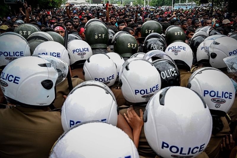 University students scuffle with police during a demonstration against the economic crisis near the parliament building in Colombo on 8 April 2022. Cash-strapped Sri Lanka's central bank hiked interest rates by a record 700 basis points 8 April as police fired tear gas at hundreds of students protesting about the economic crisis.